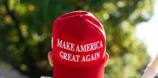 person wearing a red baseball cap at an outdoor gathering