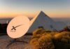 Starlink satellite dish near a pyramid-shaped building at sunset
