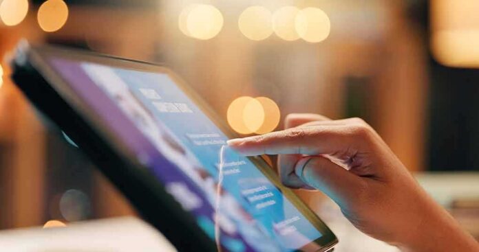 shutterstock_2475382567 Hand tapping on a tablet screen
